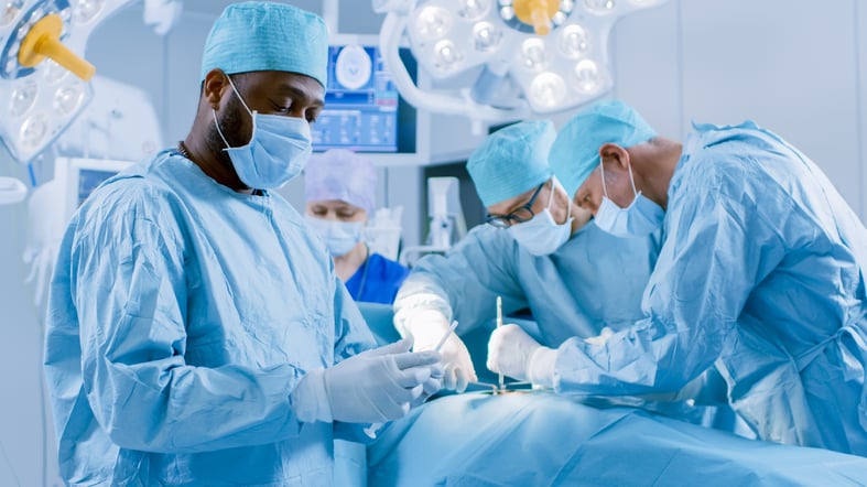 A male surgeon prepares for adenoid removal surgery at a hospital. 