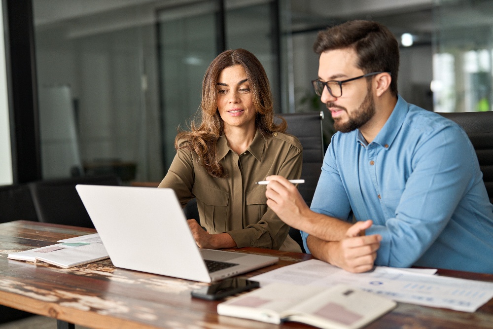 Two employees review healthcare options while sitting in an office. 