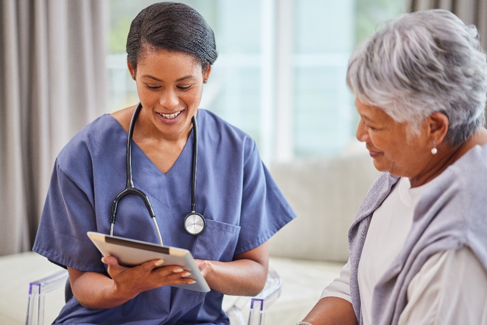 A female nurse talks to a mature female patient. 